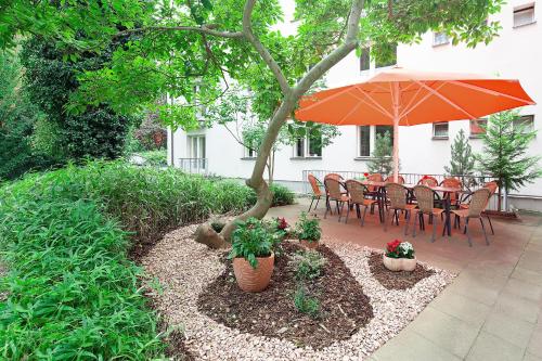 a patio with an umbrella and a table and chairs at Hotel Morgenland in Berlin