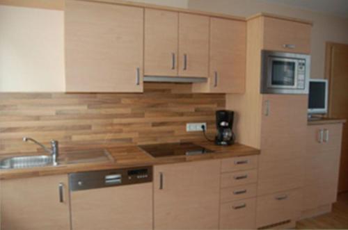 a kitchen with wooden cabinets and a sink at Apart Vita Nova in Ischgl