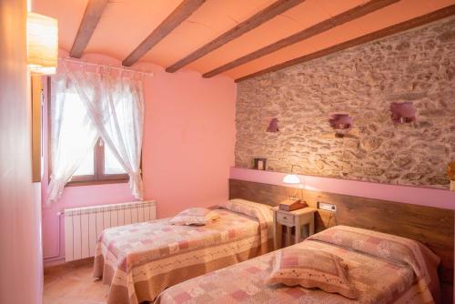 a room with two beds and a window at La Coberta-Lo Paller del Coc in Rialp