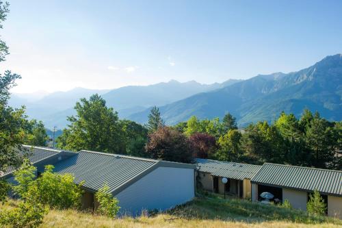 a house on a hill with mountains in the background at VTF Le Pigneroux in Savines
