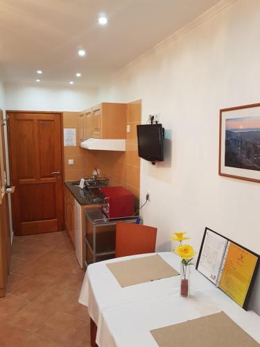 um quarto com uma mesa e uma cozinha com um lavatório em Sába-Ház em Balatonboglár