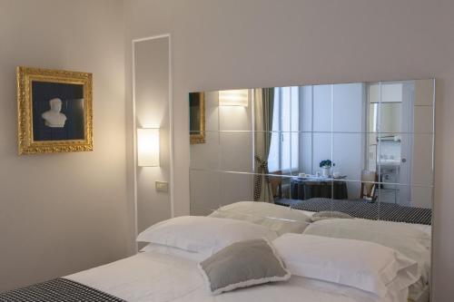 フィレンツェにあるVerdi Apartmentsのベッドルーム(白いベッド4台、鏡付)