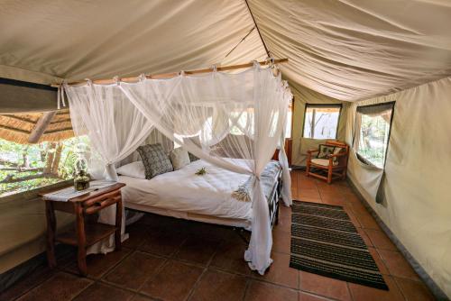 A bed or beds in a room at Pungwe Safari Camp