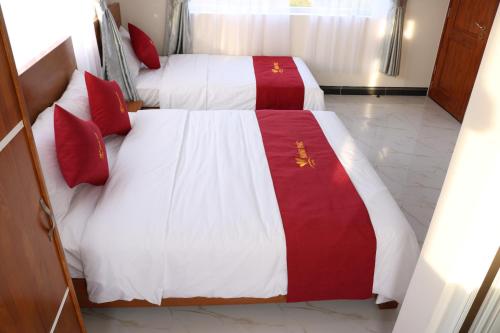 two beds in a hotel room with red and white sheets at Hoang Phuc Hotel in Thu Dau Mot