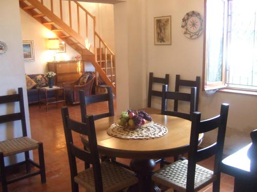 un tavolo con sedie e un cesto di frutta. di Villa Serro a Villafranca Tirrena