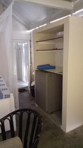 a room with a kitchen with a desk and a bed at The Tasty Tuna Cabana in Arugam Bay