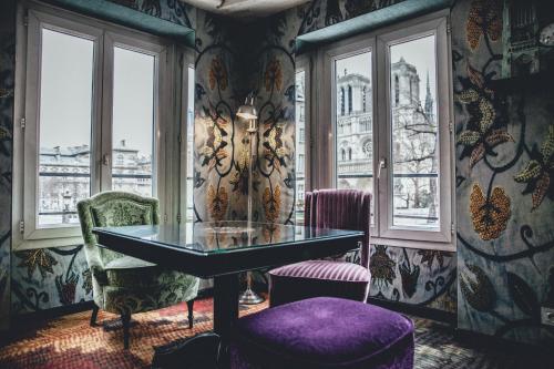 
a living room filled with furniture and a window at Hotel Le Notre Dame Saint Michel in Paris
