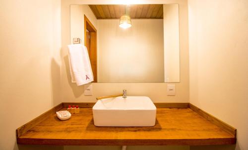 a bathroom with a white sink and a mirror at Hotel Rossomã in Praia do Rosa