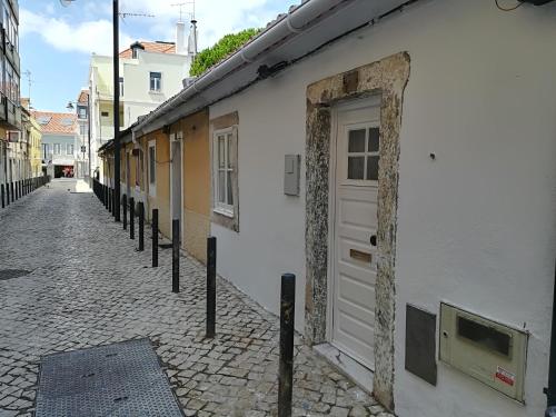 ein weißes Gebäude mit einer Tür auf einer Straße in der Unterkunft Casinhas da Ajuda nº 27 in Lissabon
