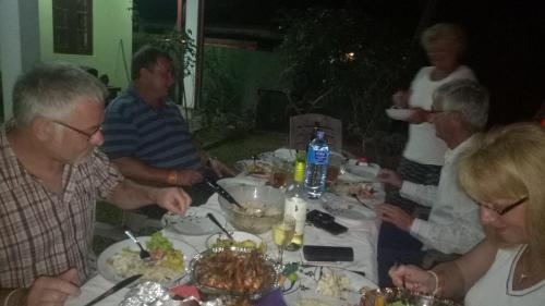 a group of people sitting around a table eating food at Mahi Villa in Bentota