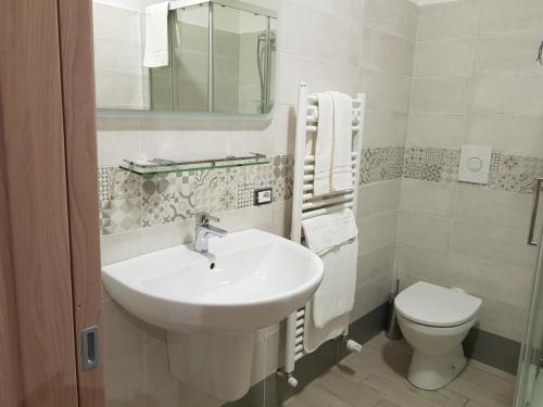 uma casa de banho branca com um lavatório e um WC em La Suite em Cassino
