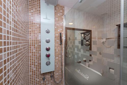 uma casa de banho com chuveiro e azulejos castanhos em Hotel Rural Santa Inés em Vinuesa