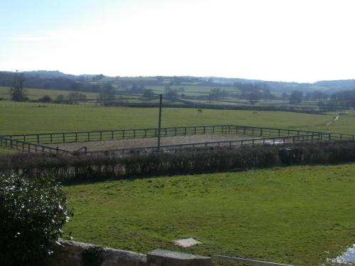 a fence in a field with sheep in the distance at Cottage 2 personnes in Lormes