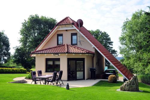 uma casa com um telhado com uma mesa e cadeiras em Ferien_HAUS AM SEE em Silz