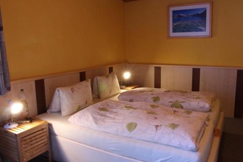 a small bedroom with a bed with two lamps at Josef Pixner in Sölden