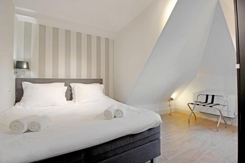 アムステルダムにある2 bedroom loft near Rijksmuseumのベッドルーム1室(大型ベッド1台、白いシーツ、枕付)