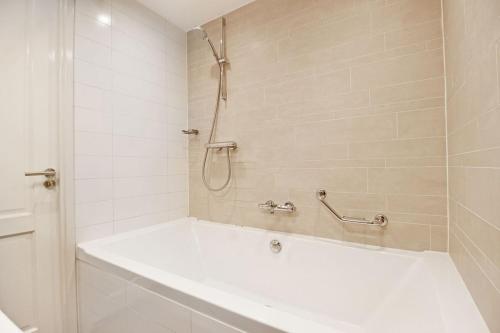 a white bathroom with a tub and a shower at 2 bedroom loft near Rijksmuseum in Amsterdam