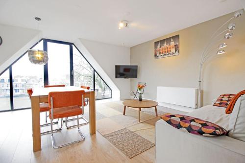 a living room with a table and a couch at 2 bedroom loft near Rijksmuseum in Amsterdam