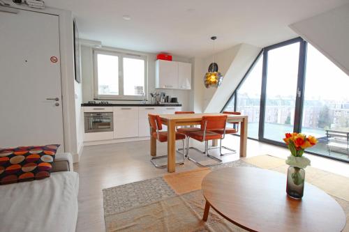 a kitchen and living room with a table and chairs at 2 bedroom loft near Rijksmuseum in Amsterdam