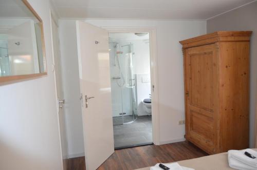 a bathroom with a shower and a toilet in it at Hotel De Waag in Bergen