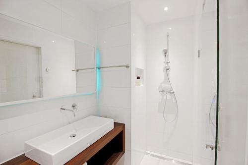 a white bathroom with a sink and a shower at Eastendroom in Amsterdam