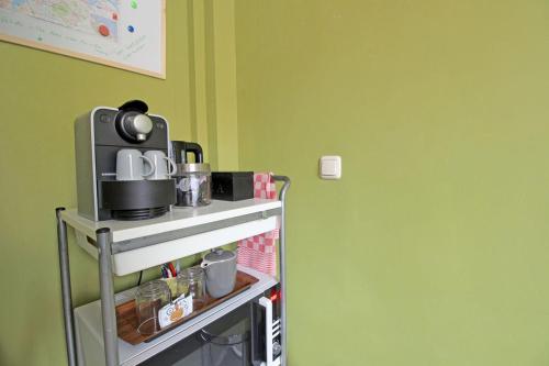 a kitchen with a coffee maker on a shelf at Eastendroom in Amsterdam