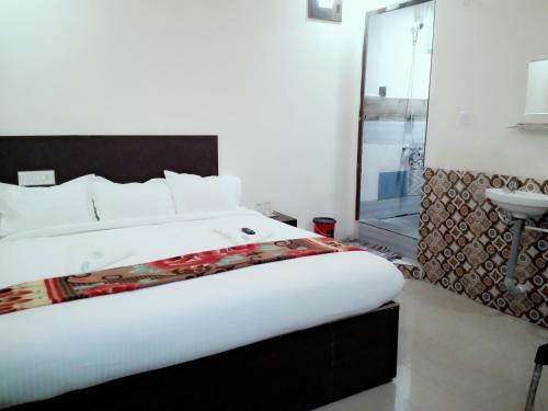 a bedroom with a large bed and a sink at Mani's residency in Madurai