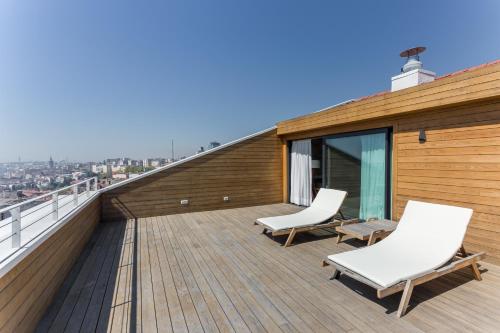 a balcony with two white chairs on a roof at Room Mate Emir in Istanbul
