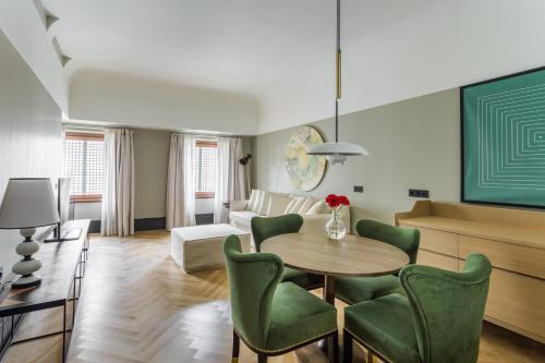 a living room with a table and green chairs at Room Mate Emir, Istanbul in Istanbul