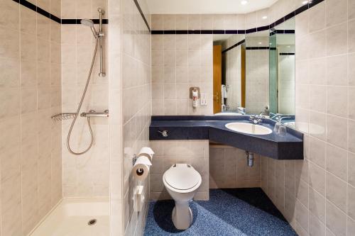 a bathroom with a toilet and a sink and a shower at ibis Preston North in Preston