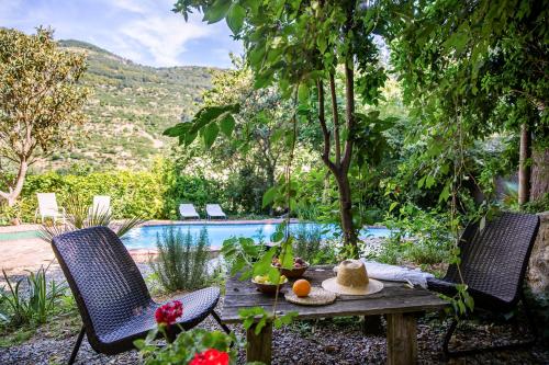 a table and two chairs in front of a pool at Casa Rural la Casa del Bosque in Navaconcejo