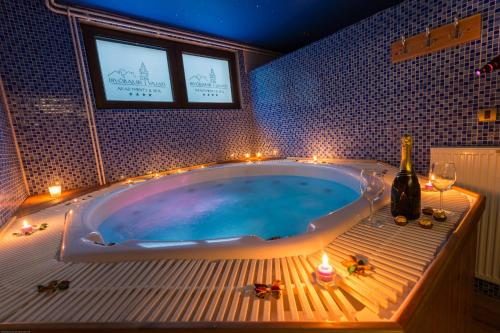 a bathroom with a tub with candles and wine glasses at Divčibarski Vajati in Divčibare