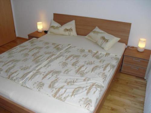a bedroom with a large bed with two candles on it at Assmanns Ferienwohnungen Ost in Miltenberg