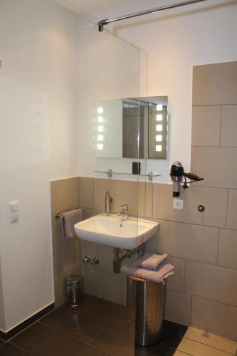 a bathroom with a sink and a mirror at Campus Boardinghouse in Aachen