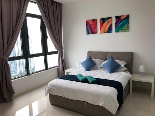 a bedroom with a large bed with blue pillows at Tropicana Suite in Petaling Jaya