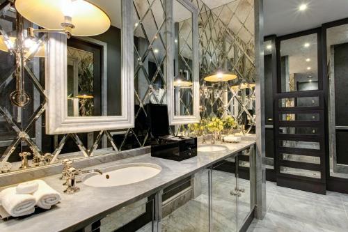 a bathroom with two sinks and two mirrors at The Franklin London - Starhotels Collezione in London