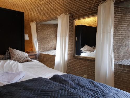 een slaapkamer met een bed en een spiegel bij Kazemat Zus in Woudrichem