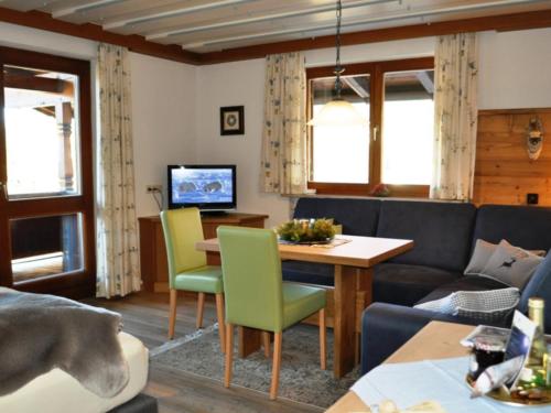 a living room with a couch and a table at Gästehäuser Schwemmbauer in Reit im Winkl