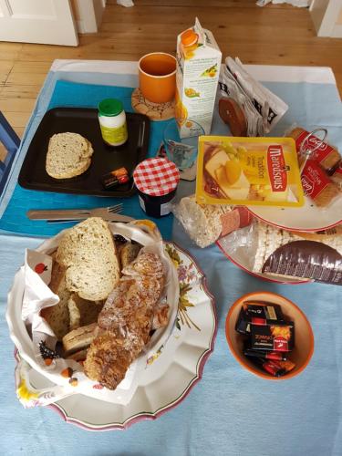 a table with a plate of bread and a tray of food at Guest House Dasos Kynthos in Brussels