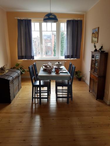 uma sala de jantar com uma mesa e cadeiras e uma janela em Guest House Dasos Kynthos em Bruxelas