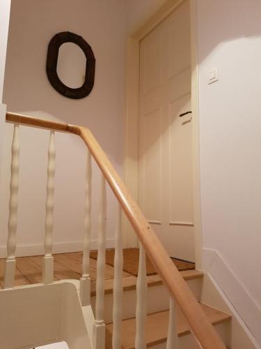 a white staircase with a wooden rail and a door at Guest House Dasos Kynthos in Brussels