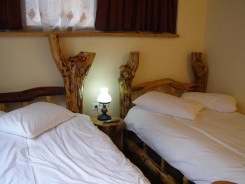 una camera con due letti e una lampada su un tavolo di El Stefano Srl a Cavnic