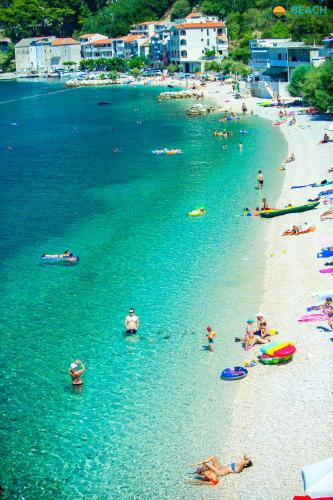 a group of people on a beach in the water at Beach Hotel in Drasnice