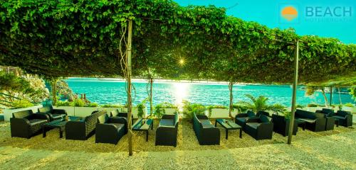a group of chairs and tables on the beach at Beach Hotel in Drasnice