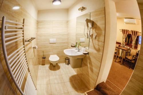 a small bathroom with a sink and a toilet at Hotel Kaskada in Poprad