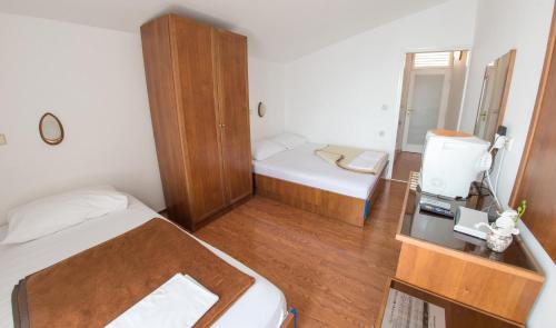 a small room with a bed and a desk with a mirror at Beach Hotel in Drasnice