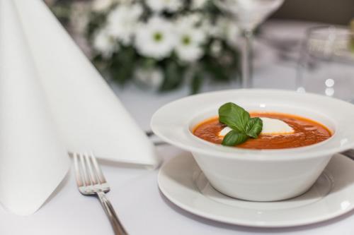 a bowl of soup on a table with a fork at Villa Bravo & SPA in Międzyzdroje
