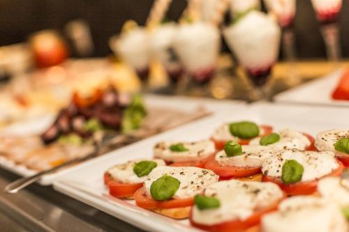 a plate of food with tomatoes and green onions at Villa Bravo & SPA in Międzyzdroje