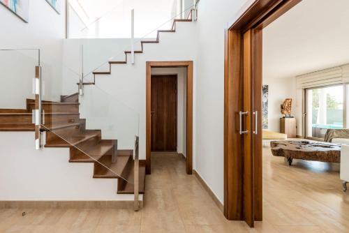 a staircase in a home with white walls and wood floors at Villa Elena in Sant Josep de sa Talaia