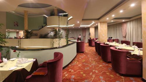 un restaurante con mesas y sillas en una habitación en Elilly International Hotel, en Addis Ababa